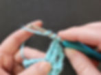Loosely held yarn overs in blue yarn on a silver and blue crochet hook.