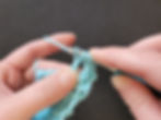 Continuing to hold onto the bottom of the treble crochet as we work it, keeping the remaining yarn over loops pushed up close to the head of the crochet hook.
