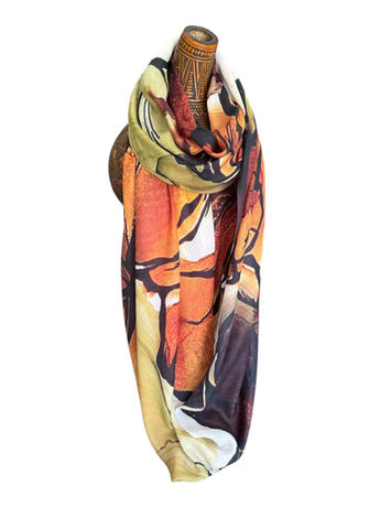 Orange and earth-toned cashmere scarf with bold, abstract patterns, draped on a mannequin.