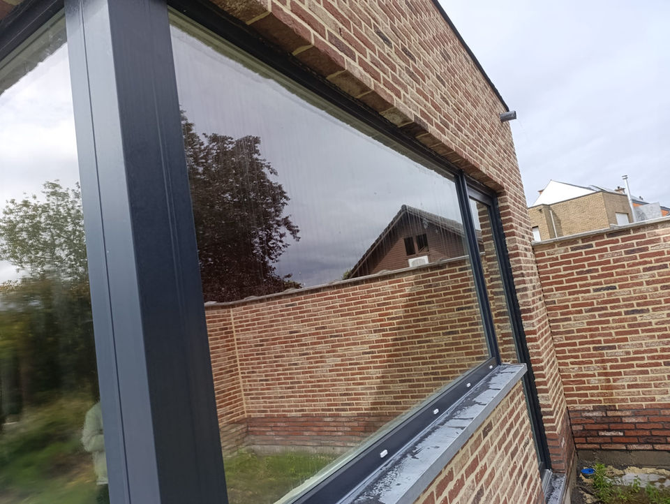 Donkergrijze aluminium ramen geplaatst in moderne woning in Leuven