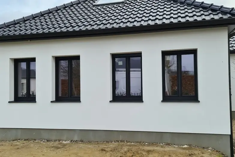 Witte gevel met donkere houten ramen.