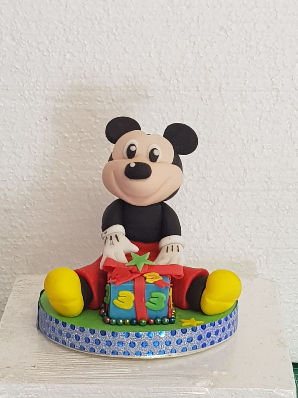 Gumpaste Micky mouse with gifts sat on cake