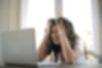 Woman staring at laptop and looking frustrated.