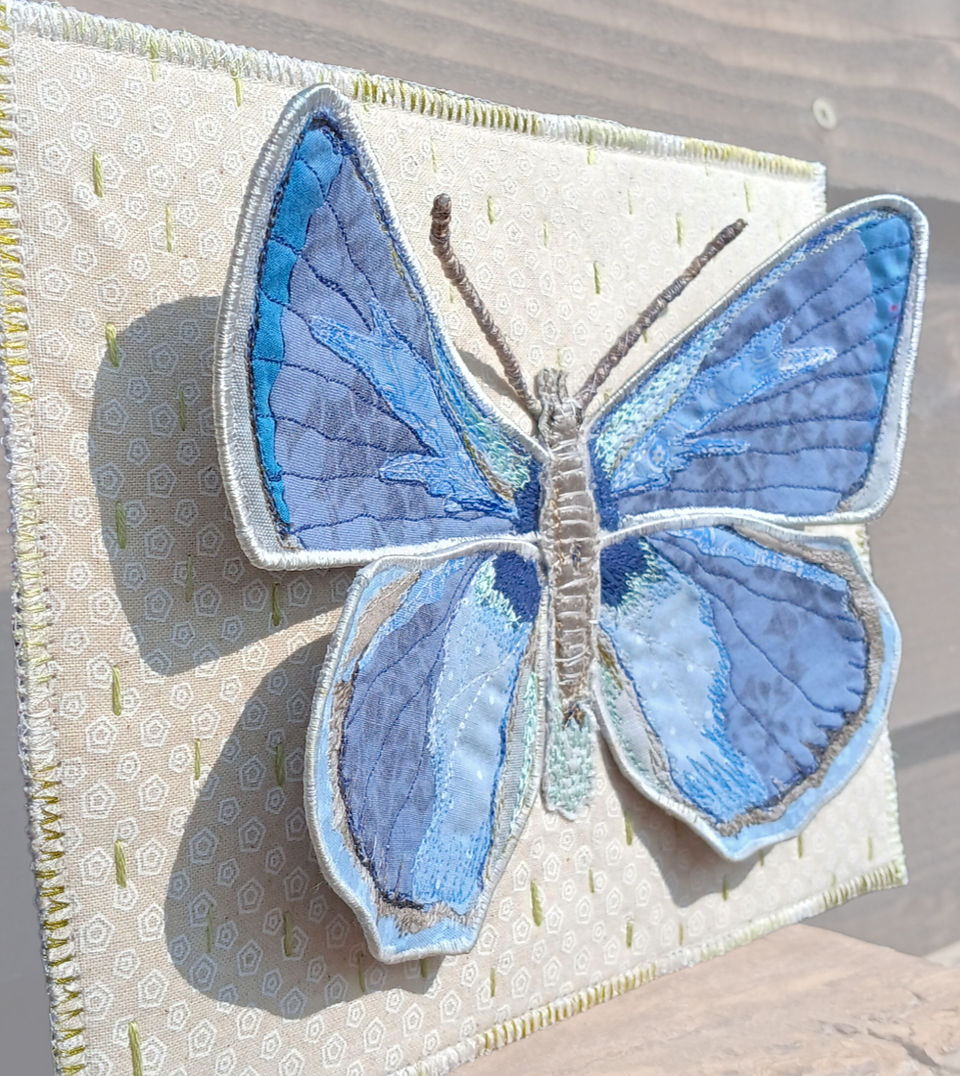 Side details showing 3D aspect of a stitched textile butterfly postcard