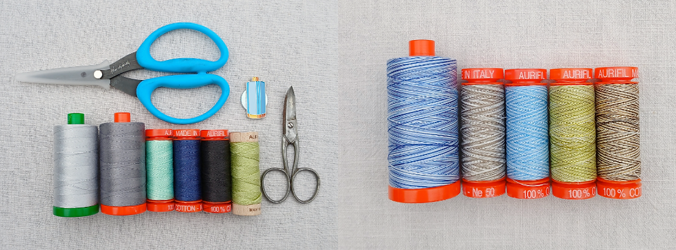 Blue Karen Ky Buckley scissors, vintage embroidery scissors and a selection of Aurifil 40wt, 50wt and Aurifloss threads in greys, green and blues, layed out with a Aurifil needle minder on linen background
