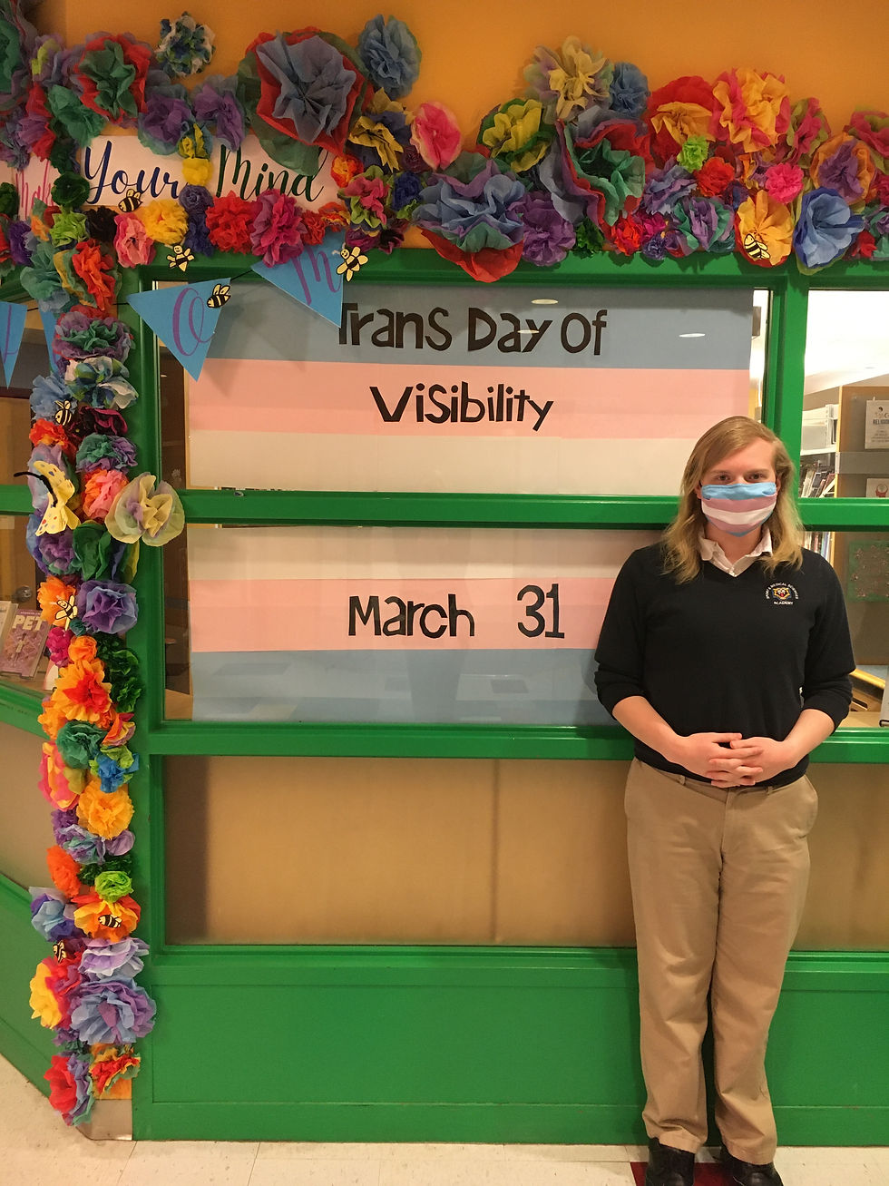 Trans Day of Visibility Display with me in front of it.jpeg