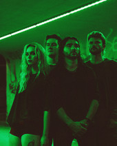 Avalon Stone and the band in a grungy alley with green lighting