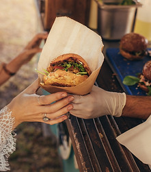 A food vendor handing a burger to a Rockberry Ranch guest.