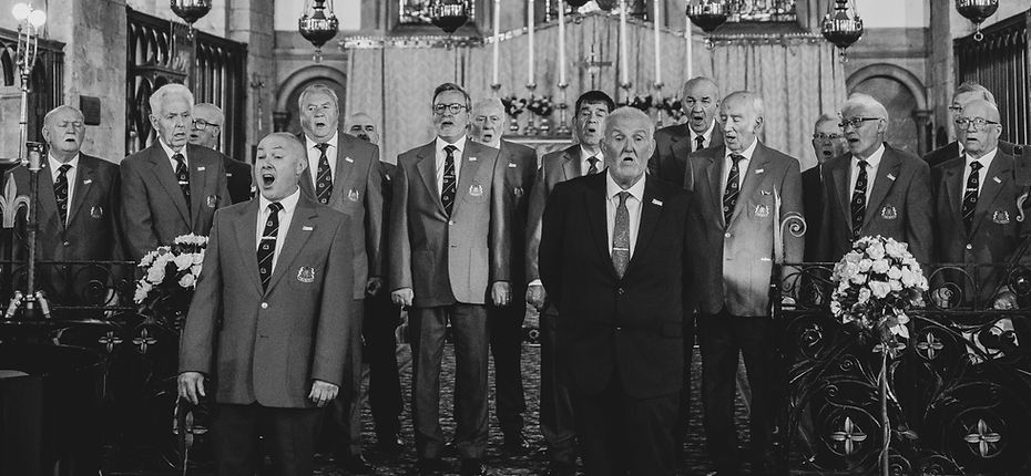 A black and white image of the Maesteg Gleemen Male Voice Choir singing at Margam Abbey