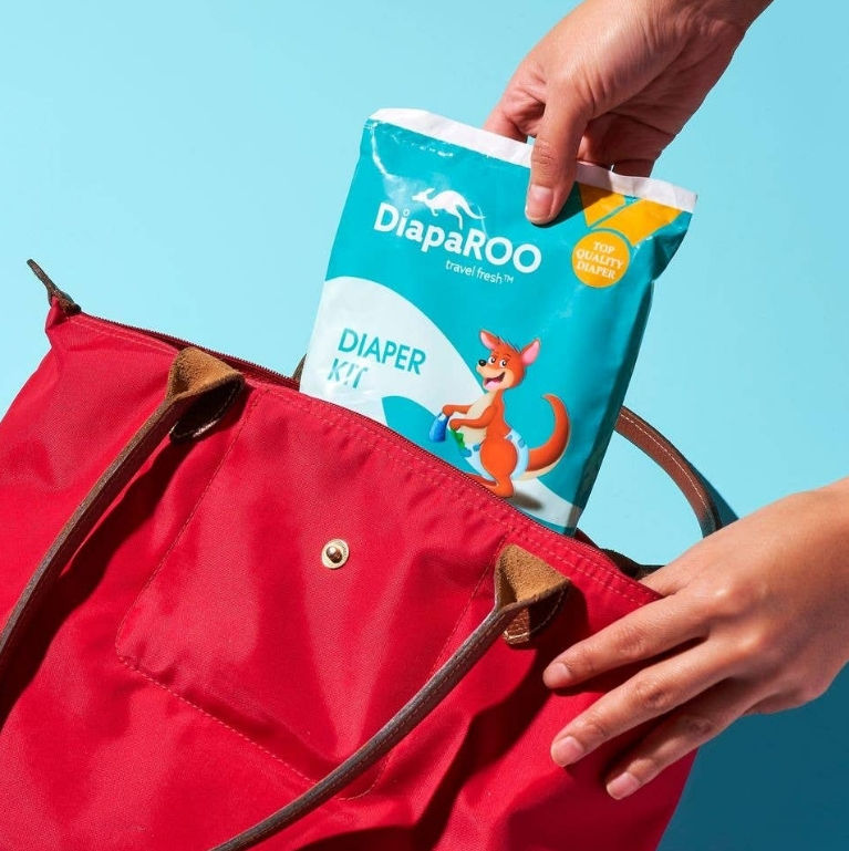 Thumbnail: DiapaROO Diaper Changing Travel Kit with diapers, wipes, gloves, and disposal bag.
