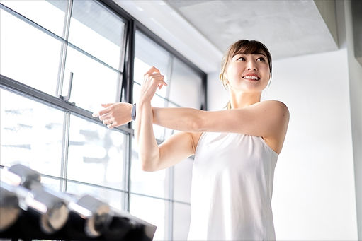 ジム内でストレッチする女性