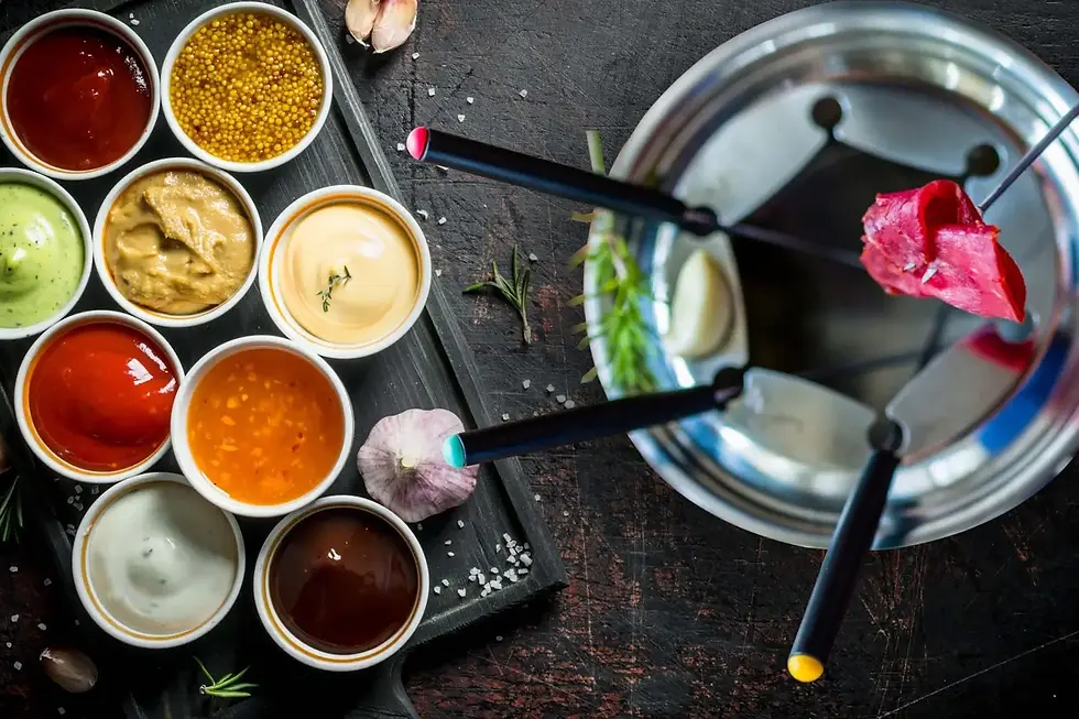 Fondue Chinoise mit verschiedenen Saucen in kleinen Schälchen und Fondue-Topf mit Fleisch – Übersicht für Fondue Chinoise Saucen-Rezepte