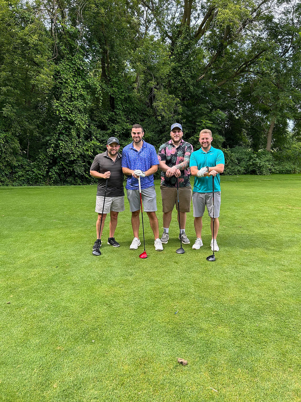 Group of friends smiling for a group photo on a golf course