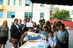 Students working on mosaic fish mural at Mercado del Barrio