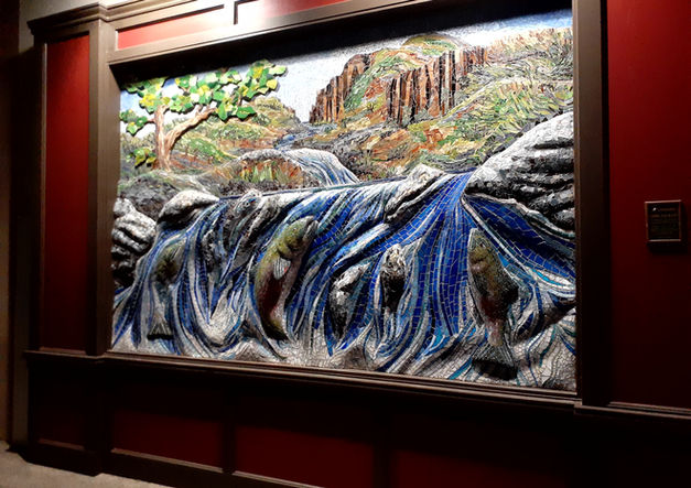 Finished mosaic of waterfall scene framed inside hotel lobby.
