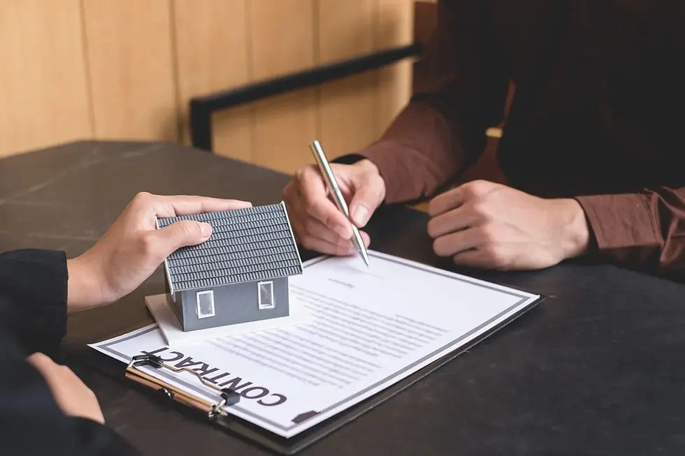 Property contract being signed with a house model on the document