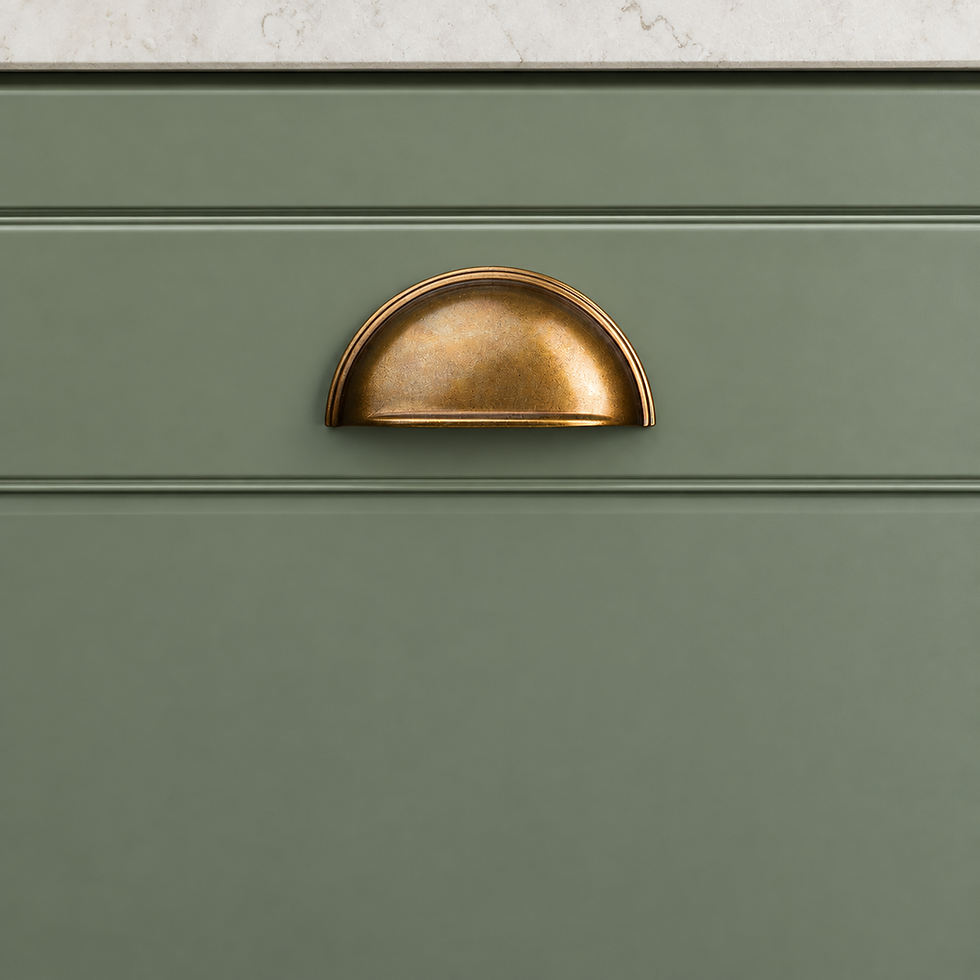 Brass cup handle on a sage green Shaker kitchen in Honiton