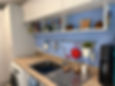 Slab door modern kitchen with blue backsplash and sink.