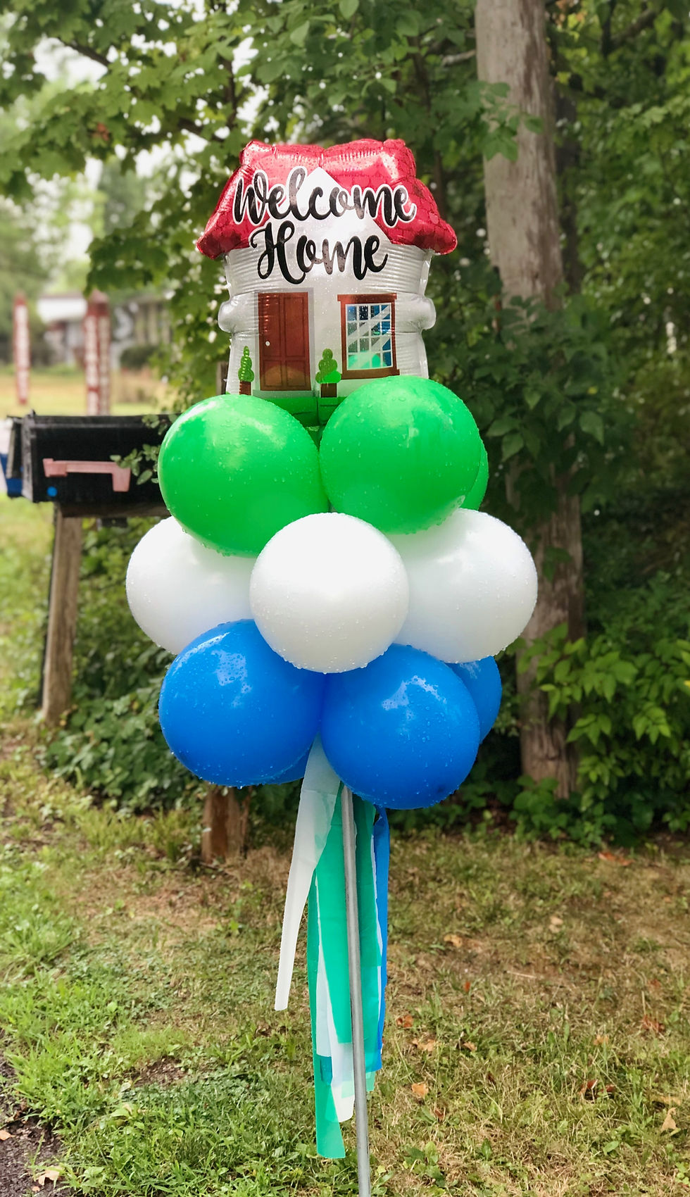 Thumbnail: Balloon topiary stake. Colors: blue, white, green. "Welcome home" mylar topping