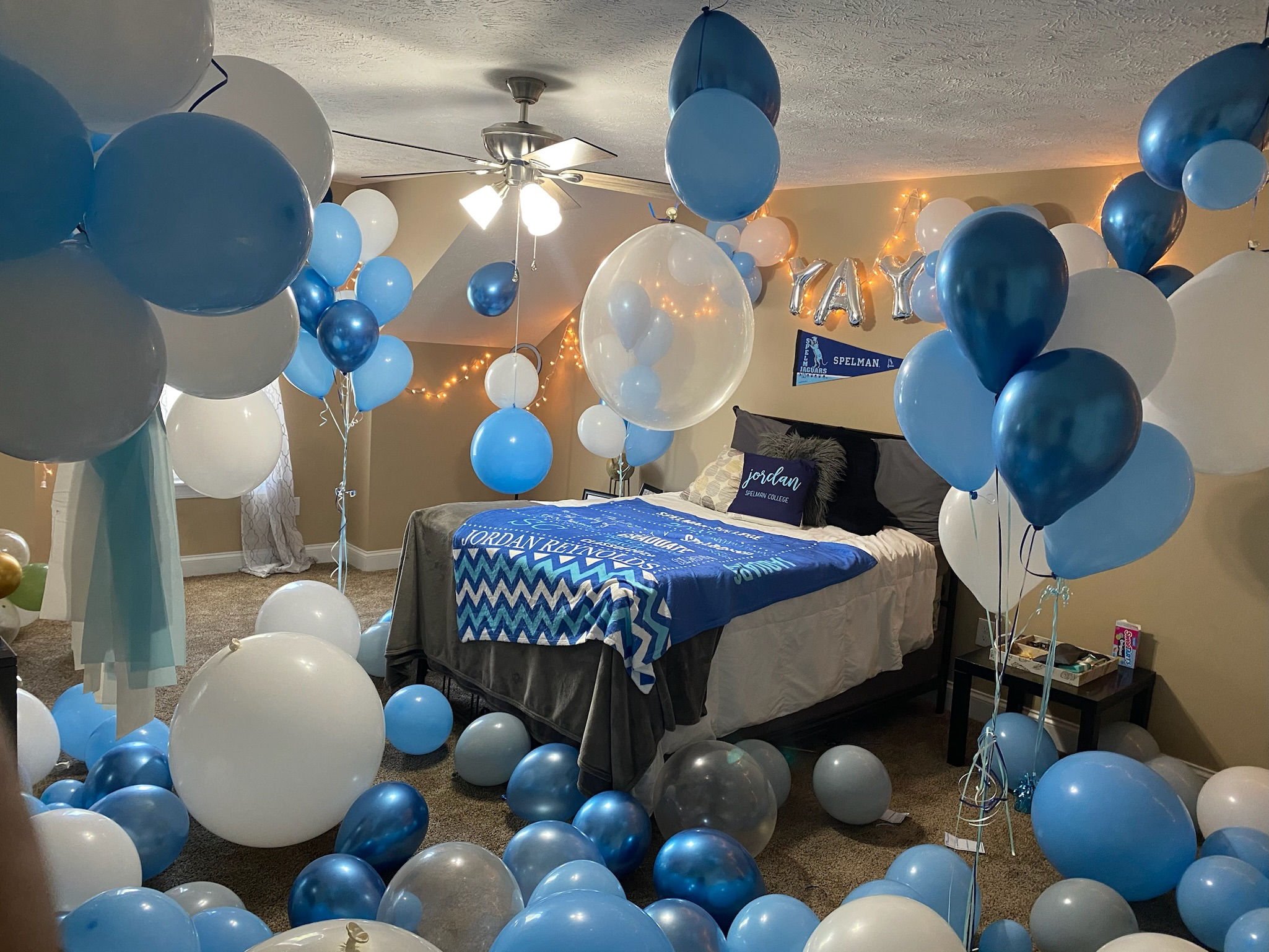 Bedroom with balloons spread on the floor, balloon bouquets everywhere. Blue and white colors