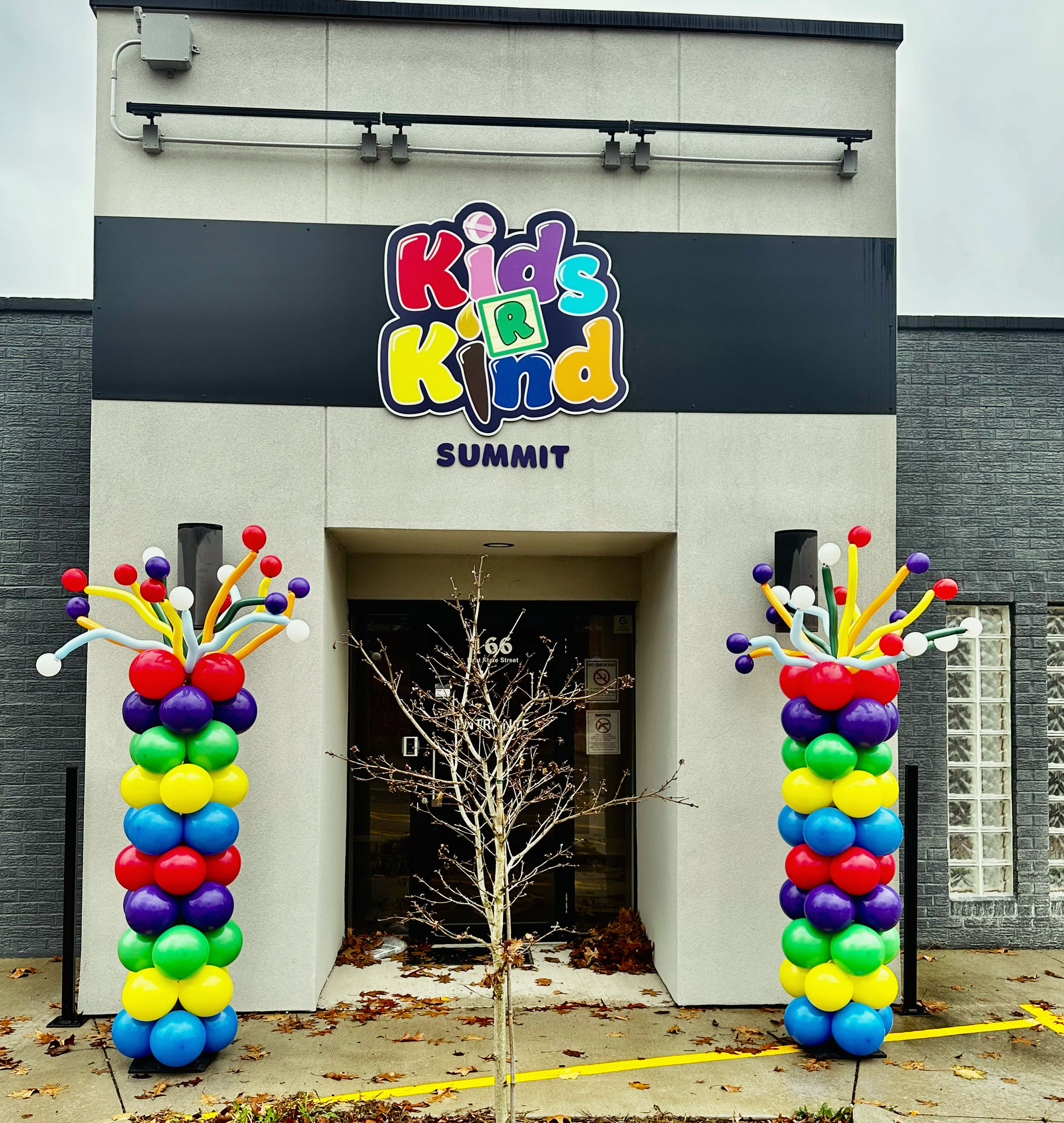 Two clorful balloon pillars placed at the entrance to "Kids 'r Kind"