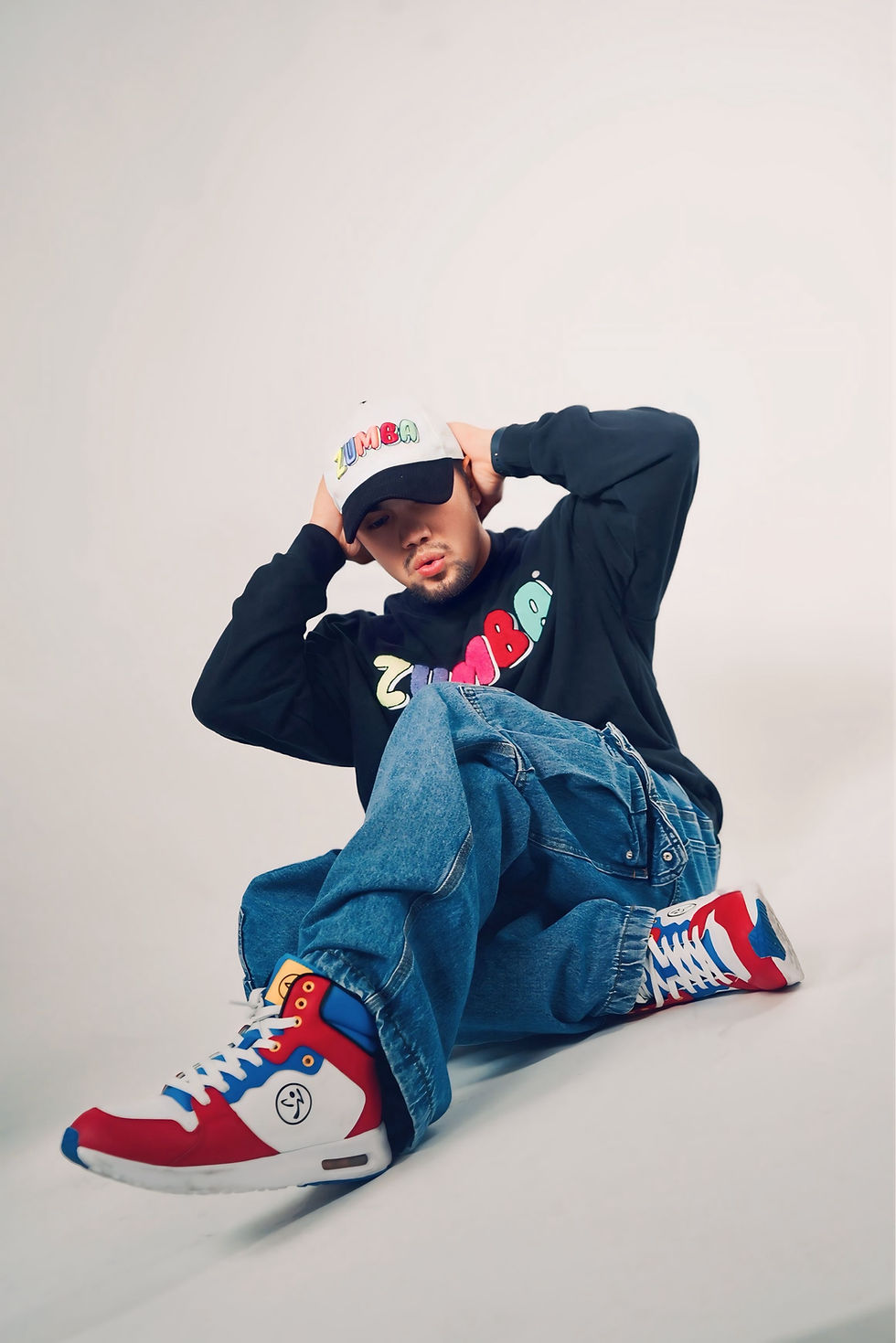 Man in a Zumba sweatshirt and high-top sneakers posing.