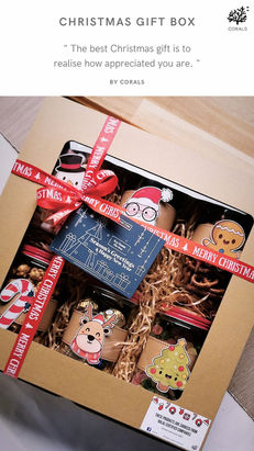 CORALS Catering premium Christmas gift box featuring festive red ribbon, gourmet snacks, cookies, chocolates, pretzels, Christmas-themed decorations, and elegant kraft gift box packaging for corporate and holiday gifting in Malaysia.