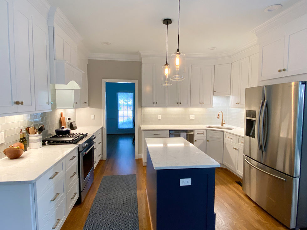 Modern kitchen with white cabinets, blue island, and stainless steel appliances. ESC Cabinets
