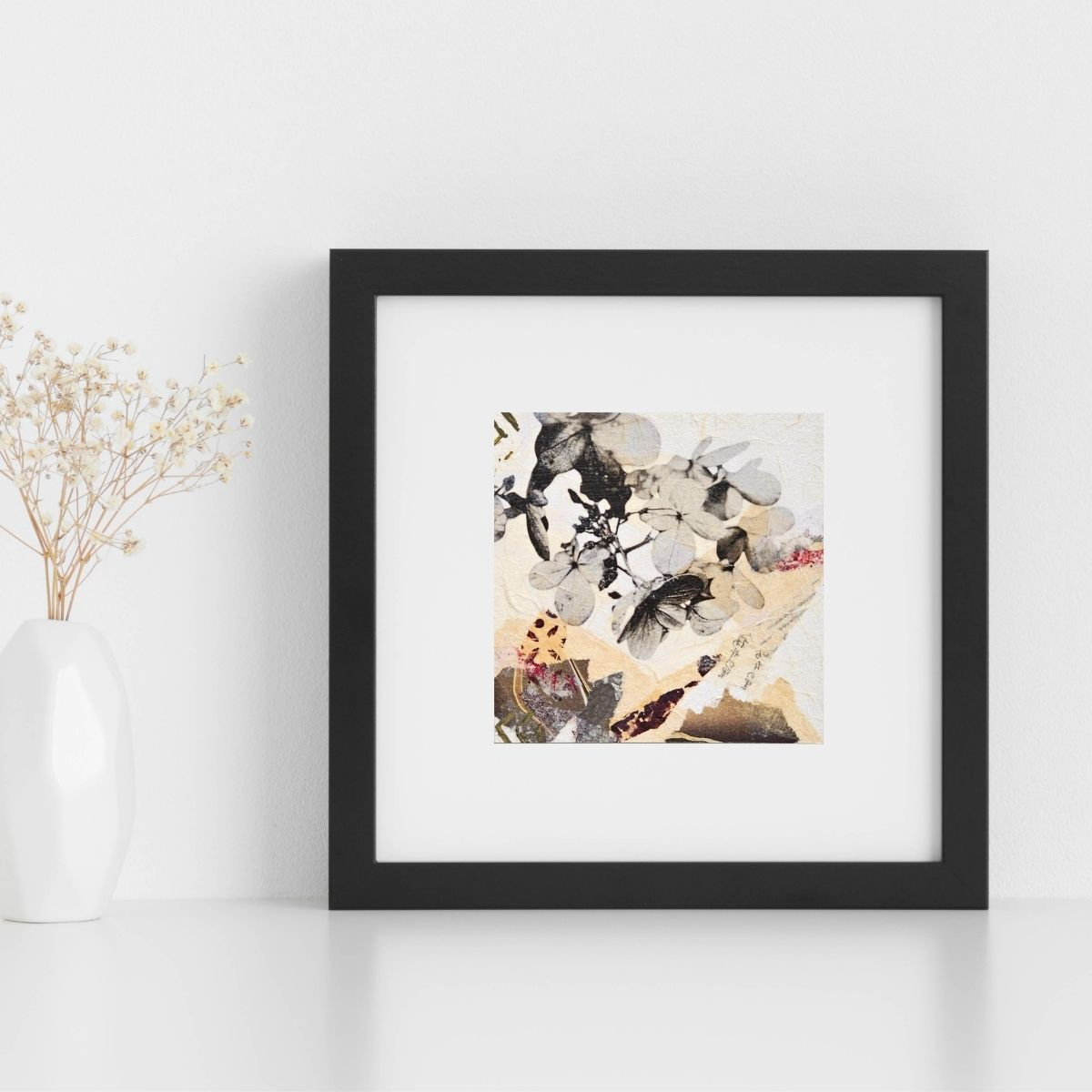 Tableau Lumière du soir, représentant des fleurs d'hortensia en gros plan, présenté posé à côté d'un vase contre un mur clair