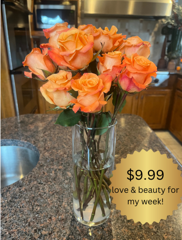 Fresh orange roses in a glass vase on a kitchen counter with a $9.99 price tag promoting beauty and love for the week.