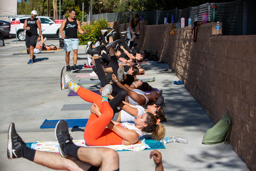 STRUT FITNESS CLIENTS DOING STRETCHES DURING AN OUTDOOR CLASS