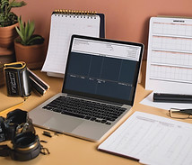 printed traditional movie shooting schedules next to a laptop with folders.jpg