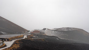 World Traveler Project. winding road through volcanic landscape with isolated building on rugged terrain, Antonis Karakonstantakis photographer, minimal mountain scene with natural textures and soft tones, travel fine art photography for wall art and interior design