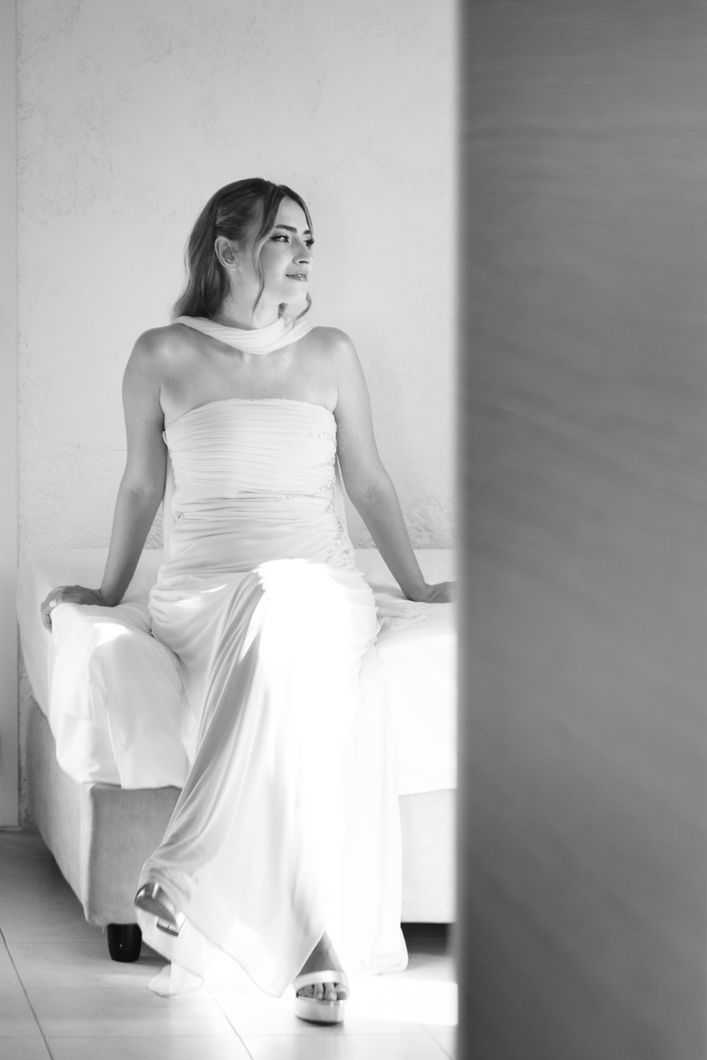 Bride sitting in a minimal interior with soft light creating a calm and elegant fine art destination wedding portrait
