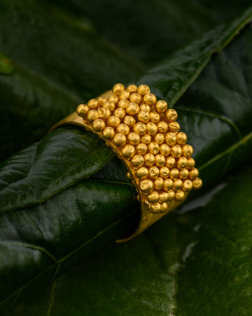 jewelry jewellery photographer based in Crete, jewelry photography with studio lighting, gold statement ring with spherical texture on green leaves, luxury product photography combining nature and design, branding image for jewelry brands and e-shop, φωτογράφιση κοσμημάτων στην Κρήτη με φυσικά στοιχεία για επαγγελματική προβολή και εμπορική χρήση