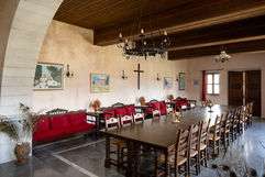 Professional interior photograph of a traditional style hospitality venue featuring long wooden tables, classic chandeliers, handcrafted furnishings, and elegant architectural details suitable for events and premium hospitality marketing.