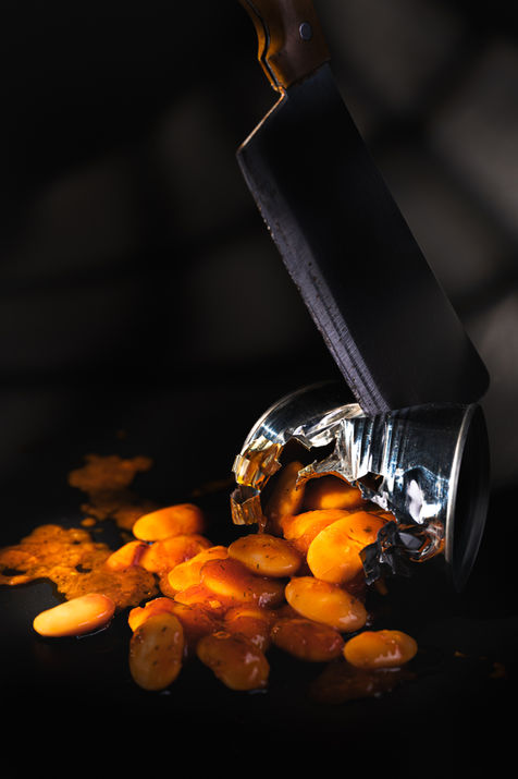 Surreal food photography by Antonis Karakonstantakis, fine art commercial photographer based in Crete, working worldwide, creative food concept with cleaver breaking metal can, φωτογράφιση φαγητού με studio lighting, beans spilling from broken tin can, cinematic composition with dramatic lighting, artistic food styling, premium advertising image, υψηλής αισθητικής εικόνα για branding και visual storytelling