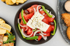 Professional food photography of a traditional Greek salad photographed from above for restaurant menus, hospitality marketing, food branding, and commercial restaurant advertising.