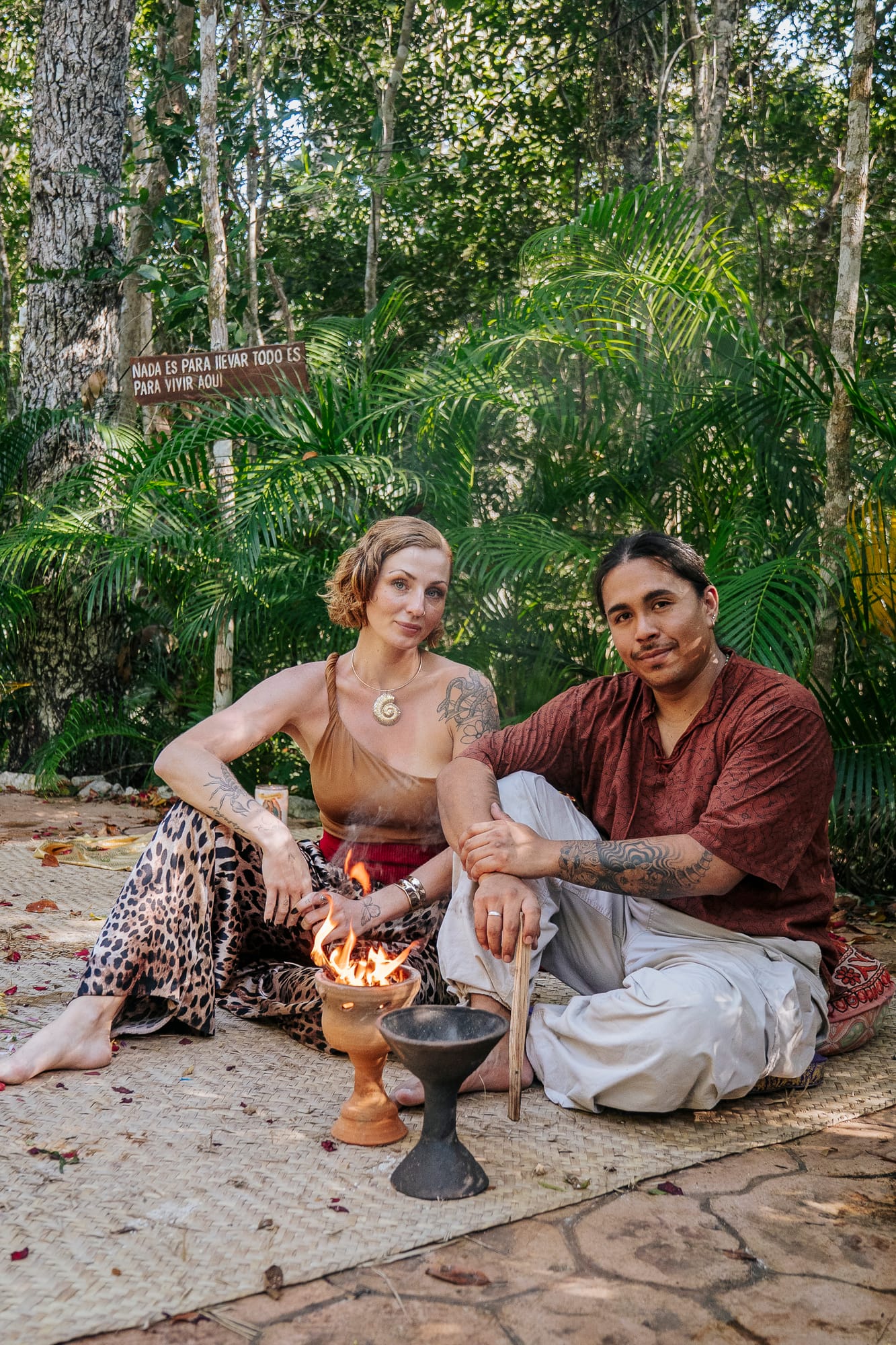 Klaudia and Ricardo Omecoatl seated by a ceremonial fire