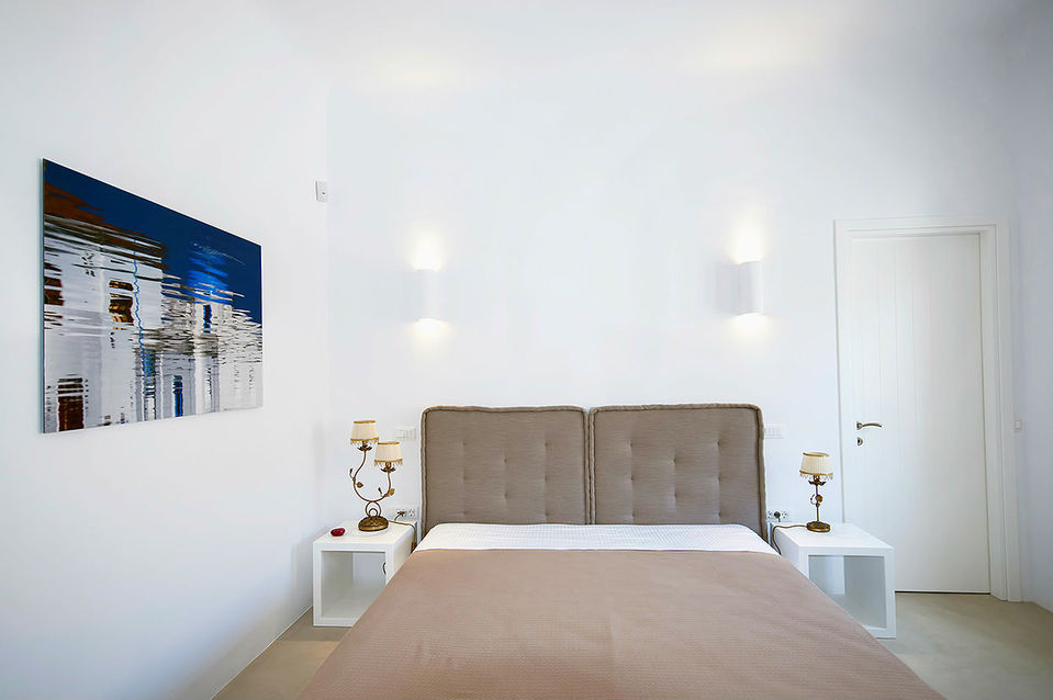 a bedroom with a painting on the wall above the bed