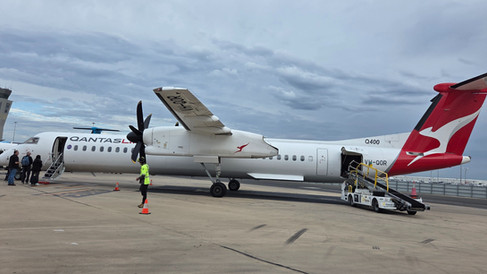 Walking to board a small QANTAS jet on a runway