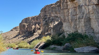 Cruising down the river with sandstone cliffs in background