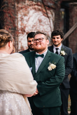 emotional groom listening to vows read by bride during rhode island wedding ceremony. Photo by Ashley Ann Films.