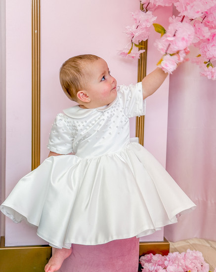 baby wearing crystal and pearl satin flower girl dress