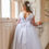 Miniature : girl wearing crystal and pearl boutique white holy communion dress with long sleeves and scalloped back with bow on back