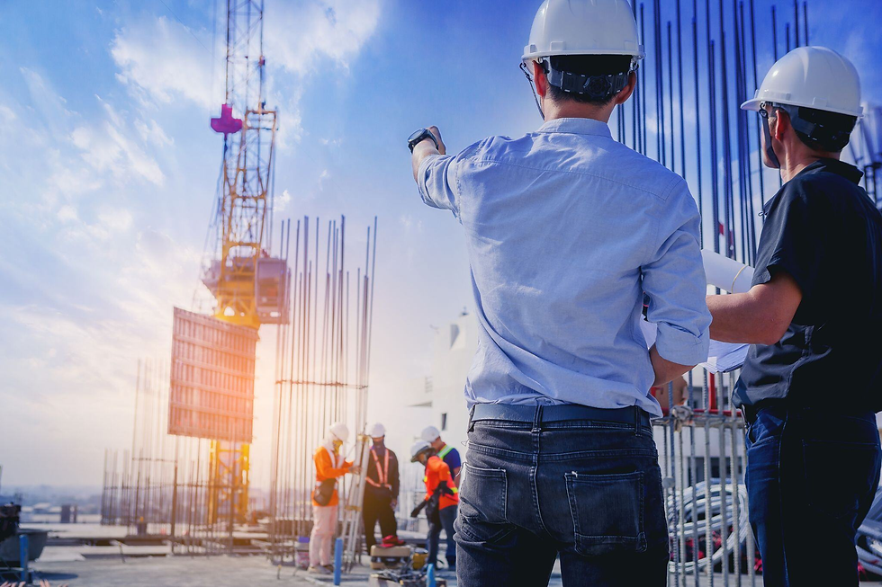 Two construction engineers in hard hats survey a rooftop site, one pointing toward a crane and steel rebar under a bright blue sky.