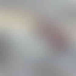 poppy seedpod drop earrings with raspberry coloured garnet cabochons on a marble background