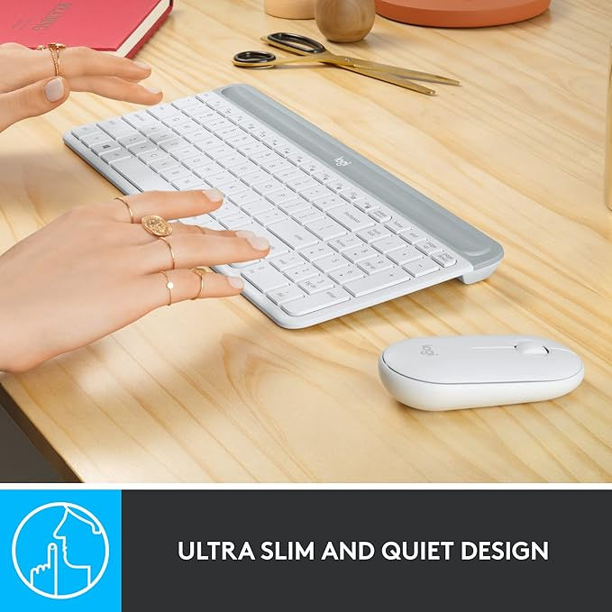 Hands typing on a white ultra-slim keyboard with a matching mouse on a wooden desk. Text reads "ULTRA SLIM AND QUIET DESIGN."