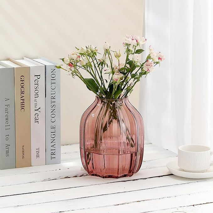 Two glass soap dispensers, labeled Pumpkin Spice and Vanilla, with gold pumps, on a wooden tray. A white cup and pinecone nearby.