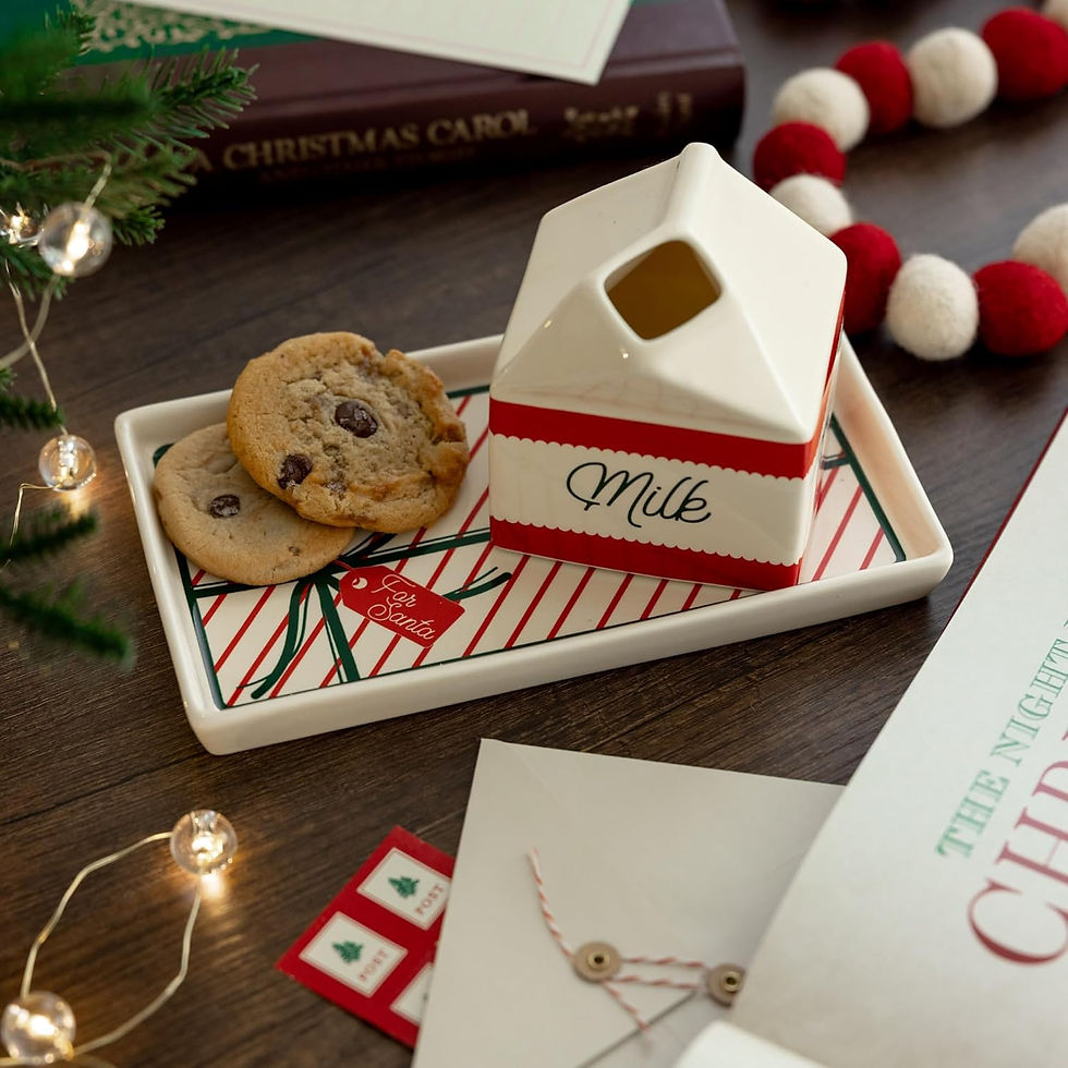 Cookies and a milk carton on a striped tray labeled "For Santa" are set on a wooden table with festive decorations and a Christmas book.